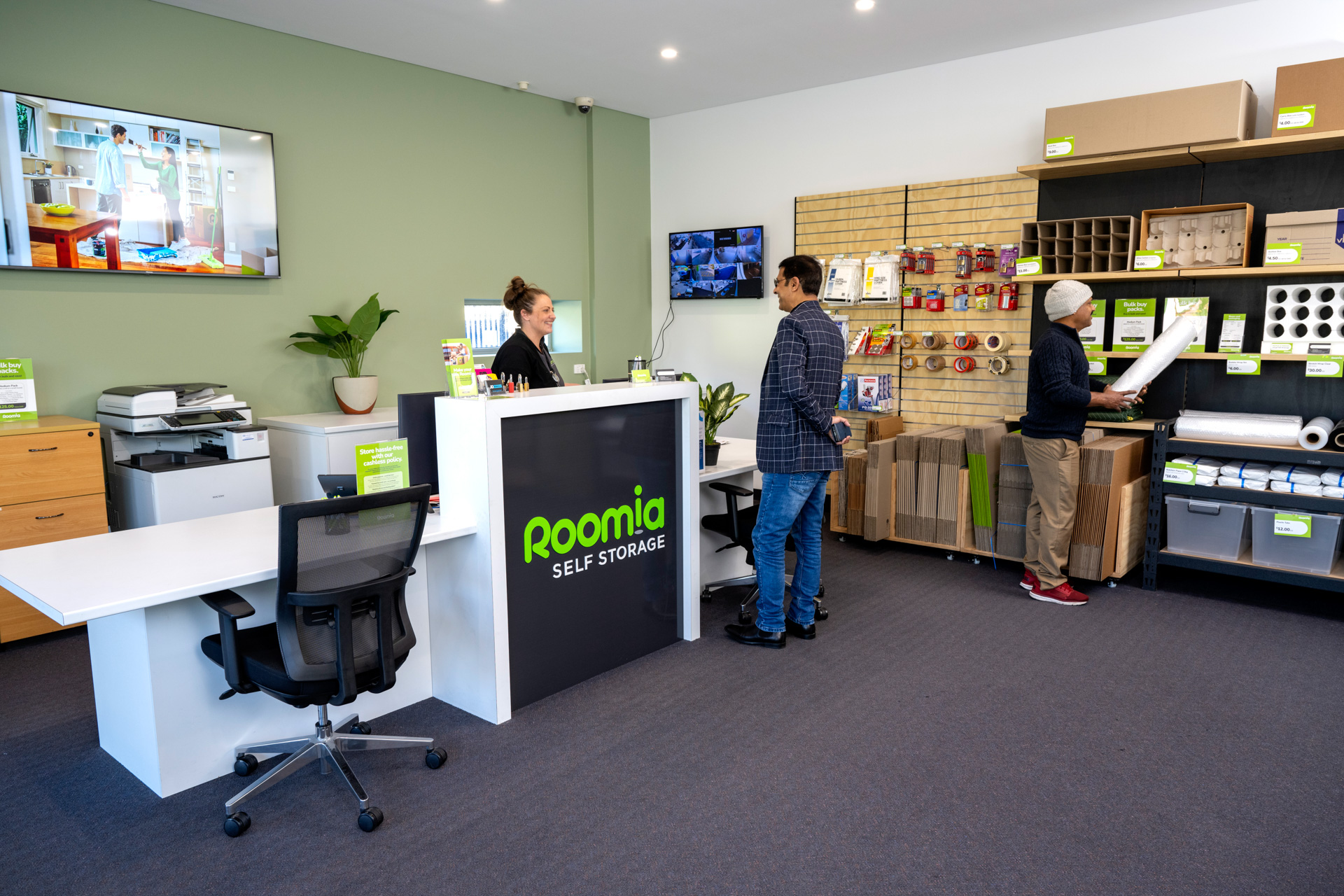 Attentive staff at Roomia Beverley self storage facility assisting a customer with a warm smile, ensuring a seamless and pleasant storage experience.