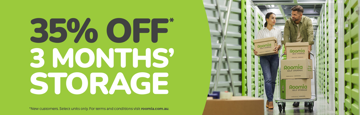 Roomia_905x290_35%_OFF_LIME_D Couple in storage facility with a Roomia box on a complimentary trolley