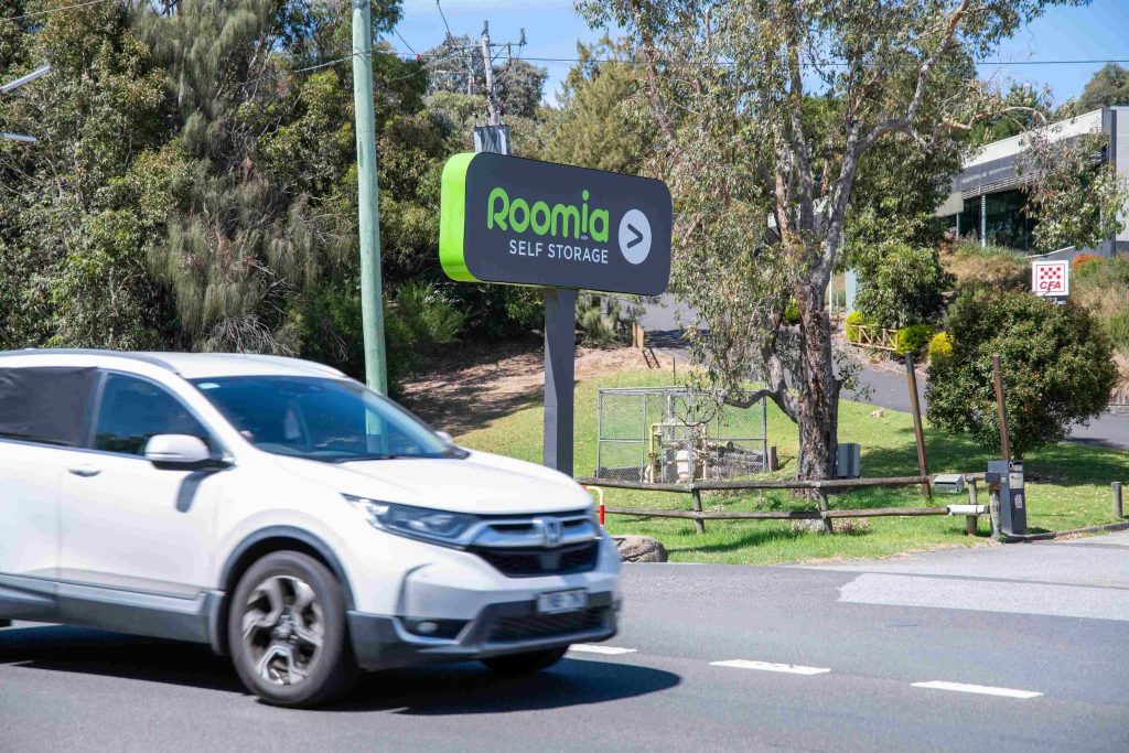 Roomia Chirnside Park welcome sign__9769com Roomia Park Chirnside Park welcome sign with white car driving past
